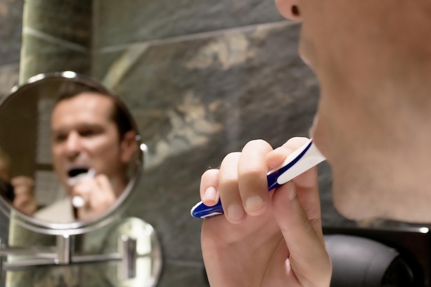 Фото Клоуз-ап человека, чистящего зубы в ванной