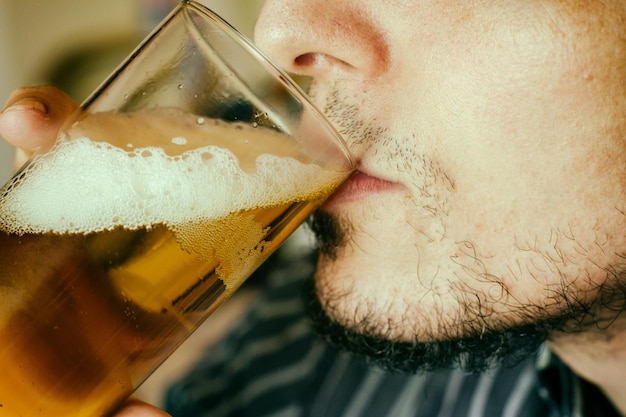 写真 ビールを飲んでいる男の顔のクローズアップ