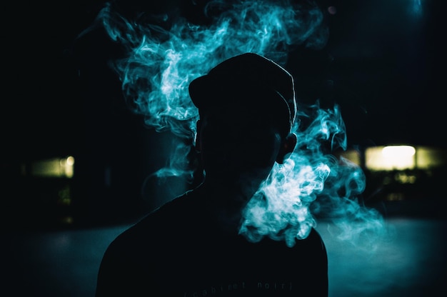 Фото Клоуз-ап мужчины, курящего сигарету ночью.