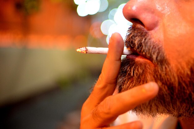 Фото Клоуз-ап мужчины, курящего сигарету.