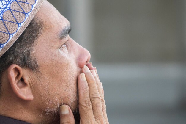 Фото Клоуз-ап взрослого человека, молящегося, сидящего в мечети