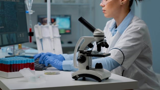 과학자가 페트리 접시를 분석하는 동안 현미경 도구 클로즈업