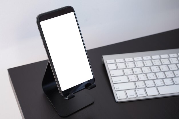 Фото Близкий план мобильного телефона и компьютерной клавиатуры на столе