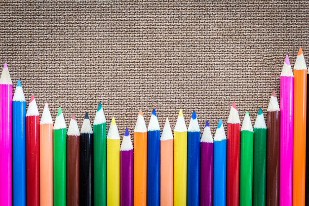 Фото Клоуз-ап многоцветных карандашей на шерстяной ткани