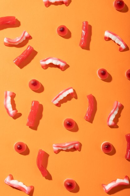 Фото Близкий взгляд на несколько конфет хэллоуина с копировальным пространством на оранжевом фоне. празднование хеллоуина и концепция празднования