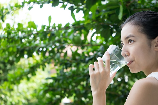 ガラスからのかわいい女の子の飲み水のクローズアップ