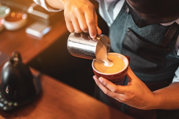사진 아름다운 라떼 아트를 만드는 커피 컵에 찐 우유를 붓고 전문적으로 커피를 추출하는 바리스타의 클로즈업. 커피, 추출, 깊은, 컵, 예술, 바리스타 개념.
