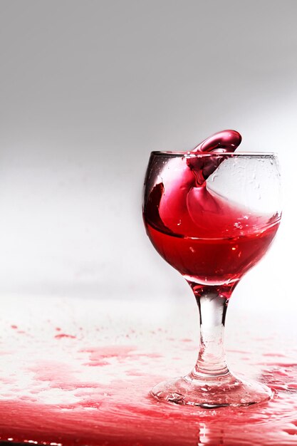 사진 색 바탕에 있는 테이블 위의 잔에 흘린 와인의 클로즈업.