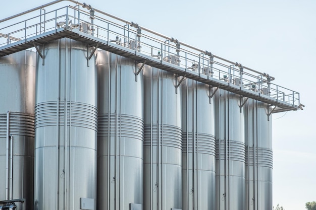 Фото Закрытие вертикальных резервуаров из нержавеющей стали для ферментации и созревания вина в современных условиях