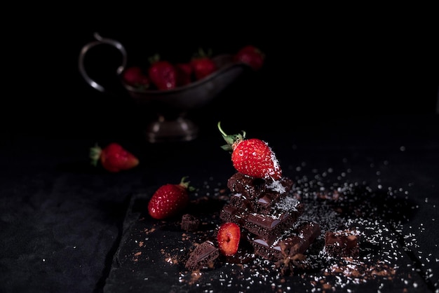 写真 黒い背景のテーブル上のチョコレートとストロベリーのクローズアップ