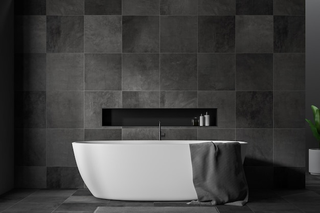 사진 검은색 타일 벽과 바닥이 있는 세련된 욕실 인테리어, 회색 수건이 걸려 있는 흰색 욕조, 회색 깔개를 갖추고 있습니다. 3d 렌더링