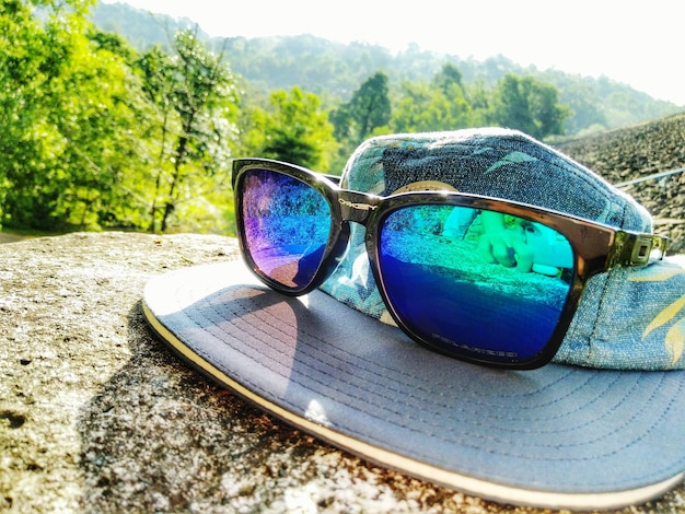 Фото Клоуз-ап солнцезащитных очков на зеркале на фоне неба
