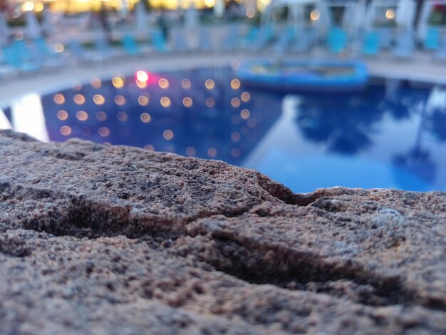 Фото Близкий взгляд на текстурированную породу у бассейна во время захода солнца