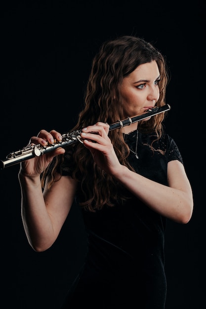 Фото Крупный план рук женщины, играющей на флейте. музыкальная концепция.
