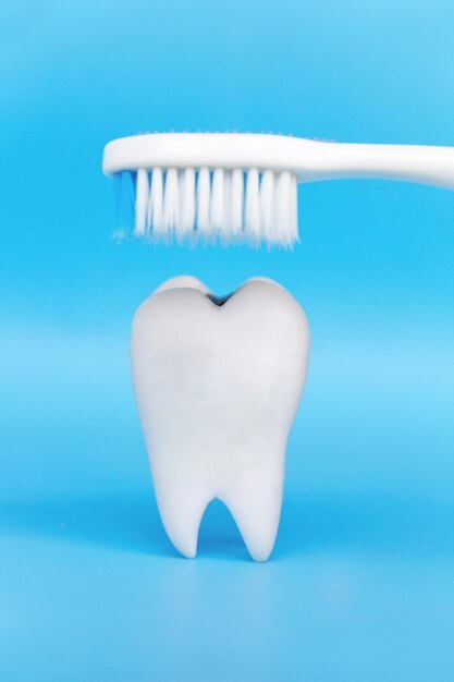 Фото Близкий план зубной щетки над зубными протезами на синем фоне