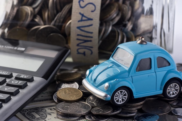 Фото Крупный план игрушечного автомобиля с помощью калькулятора и валюты на белом фоне