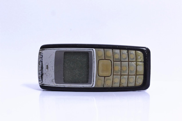 Фото Клоуз-ап старинного мобильного телефона на белом фоне