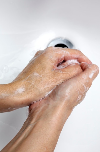 Фото Клоуз-ап женской руки на мокром полу на белом фоне