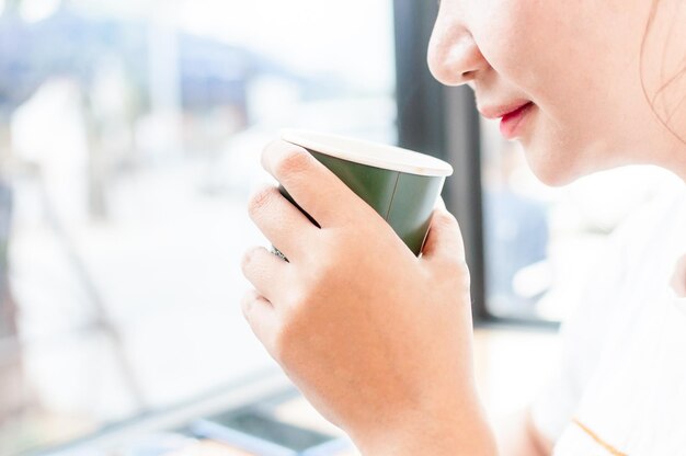 写真 コーヒーカップを握っている女性のクローズアップ