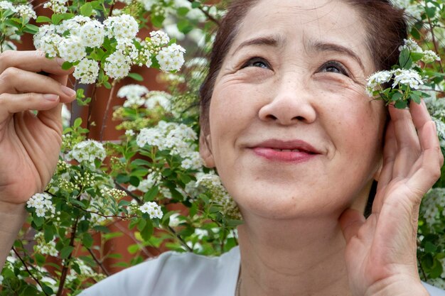 写真 花を ⁇ かせる植物のそばに立っている女性のクローズアップ