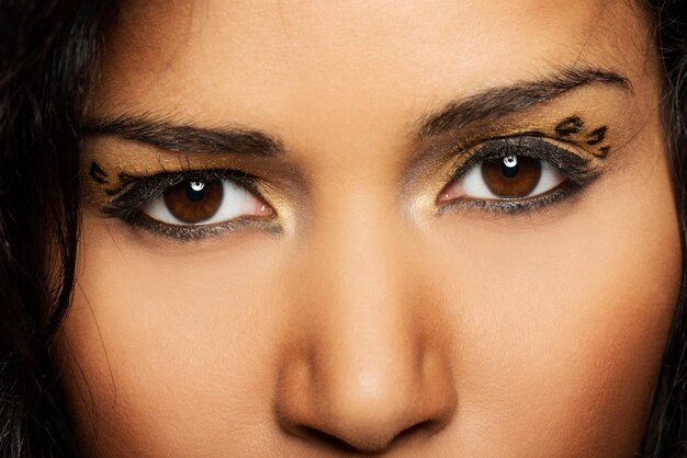 Фото Клоуз-ап женщины с макияжем на глазах на черном фоне