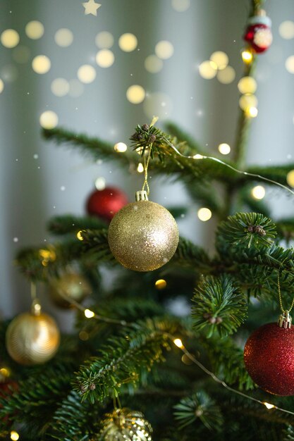 사진 크리스마스 나무에 있는 크리스마스 공의 클로즈업, 배경에 있는 보케 꽃줄, 신년 콘셉트 하이
