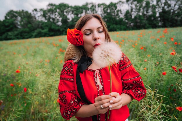 写真 畑のマグロの花のそばに立っている若い女性のクローズアップ