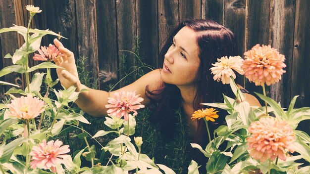 写真 花と植物を持つ若い女性のクローズアップ