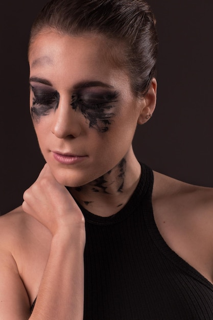Фото Клоуз-ап молодой женщины с грязным макияжем на черном фоне