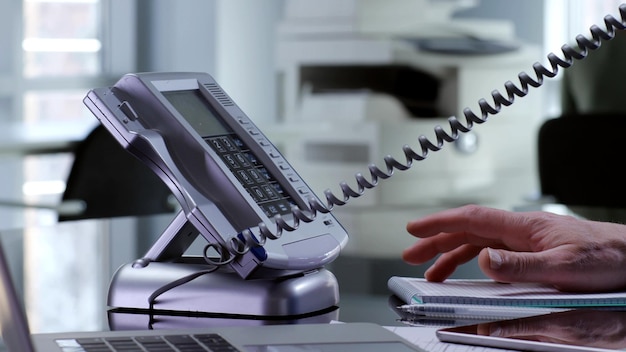 Photo close up of office employee answer telephone on desk