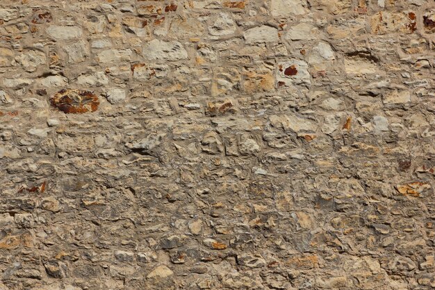 Close up old cracked yellow brick wall Texture of medieval stone wall