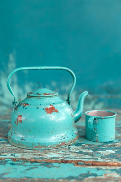 Foto un primo piano del vecchio bollitore e della tazza su un tavolo invecchiato.