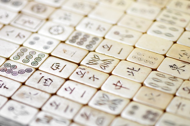 Close up on old Mahjong tiles with Chinese script in an oblique angle view