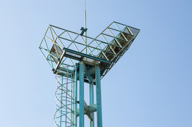 Close-up of old metal watch tower against light sky