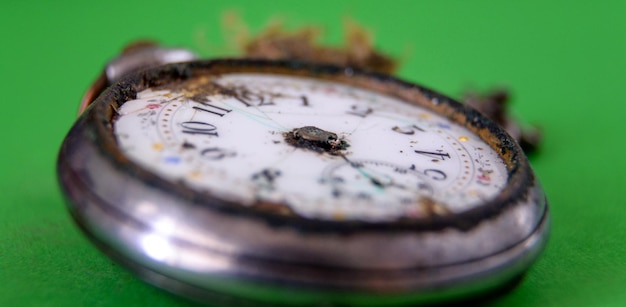 Close-up of old pocket watch on green table