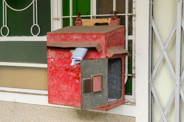 Close-up of old red mailbox on wall