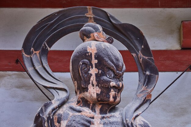 Foto close-up di una vecchia statua contro il muro