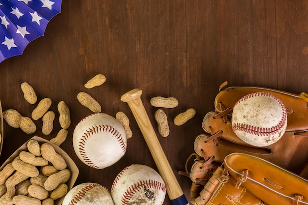 Foto chiuda in su della vecchia attrezzatura da baseball usurata su uno sfondo di legno.