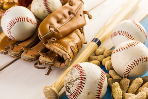 Photo close up of old worn baseball equipment on a wooden background.