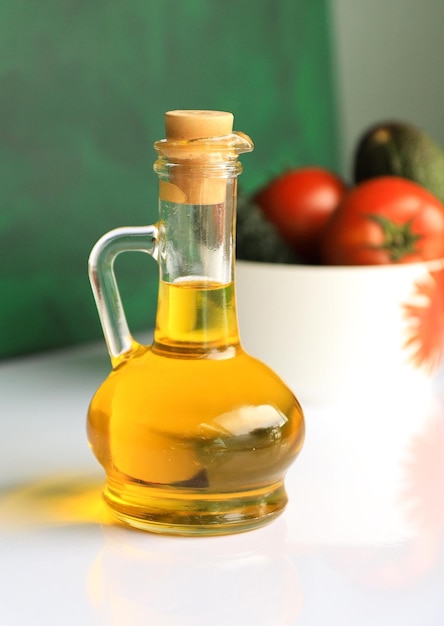 Close-up of olive oil jar in glass on table with a salad