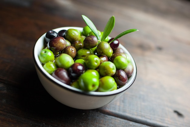 close-up of olives in bowl on wooden table
