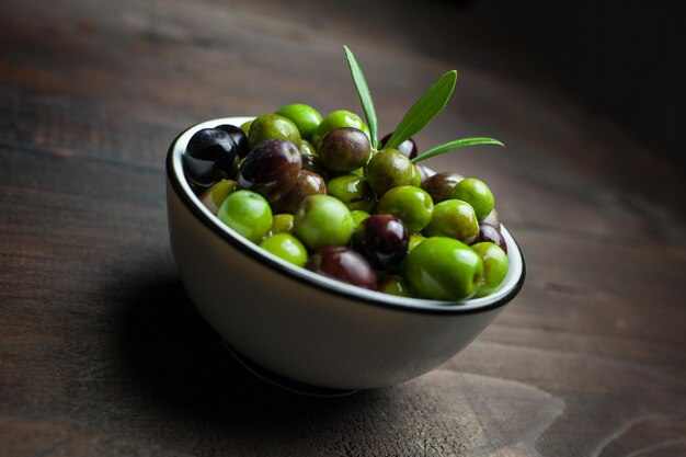 close-up of olives in bowl on wooden table