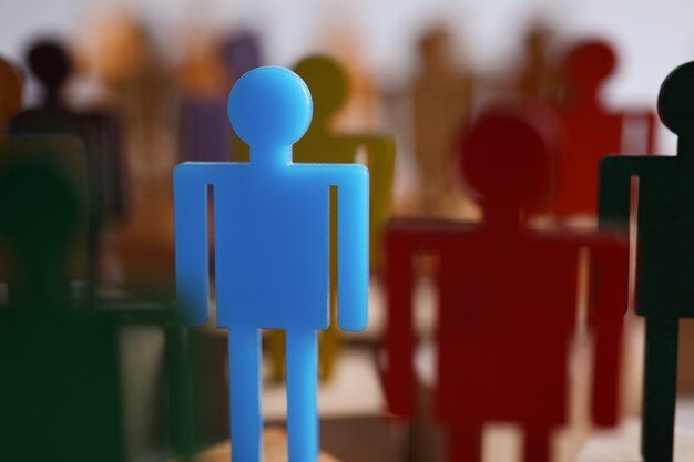 Close-up of one special guy talented businessman person among ordinary people. Unique blue figure in crowded place, stand out idea. Success, leader, career growth concept. Blurred background