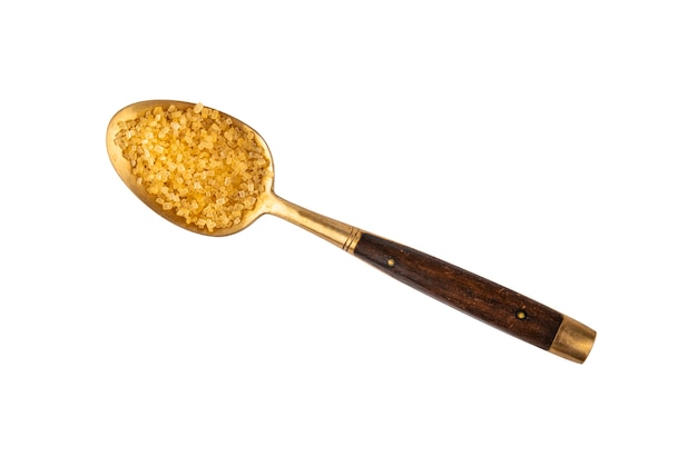 Close up one vintage golden metal spoon with wooden handle full of raw brown cane sugar, isolated on white, elevated top view, directly above