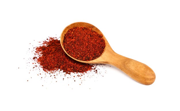 Close up one wooden scoop spoon full of ground sundried tomatoes, heap of powder spilled around, isolated on white background, high angle view