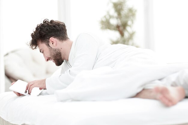 Close-up-ontwaakte man aan het typen met een digitale tablet