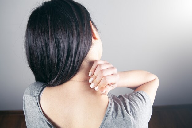 Close-up op de hand van een vrouw die haar nek masseert. de nek van het meisje doet pijn