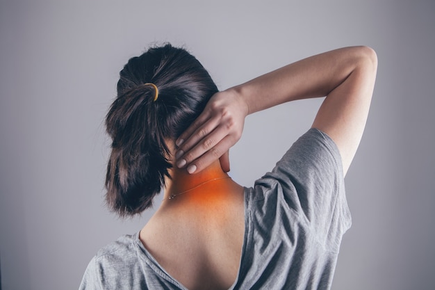 Close-up op de hand van een vrouw die haar nek masseert