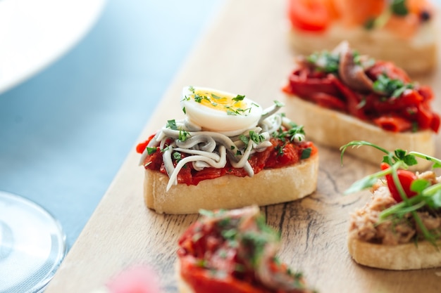 Close-up op diverse tapas met verschillende toppings op het houten bord