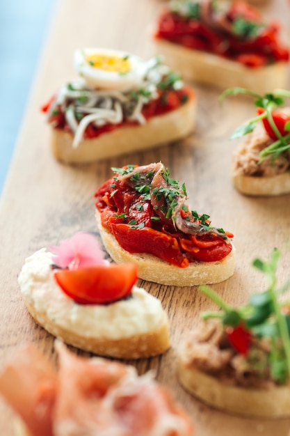 Close-up op diverse tapas met verschillende toppings op het houten bord